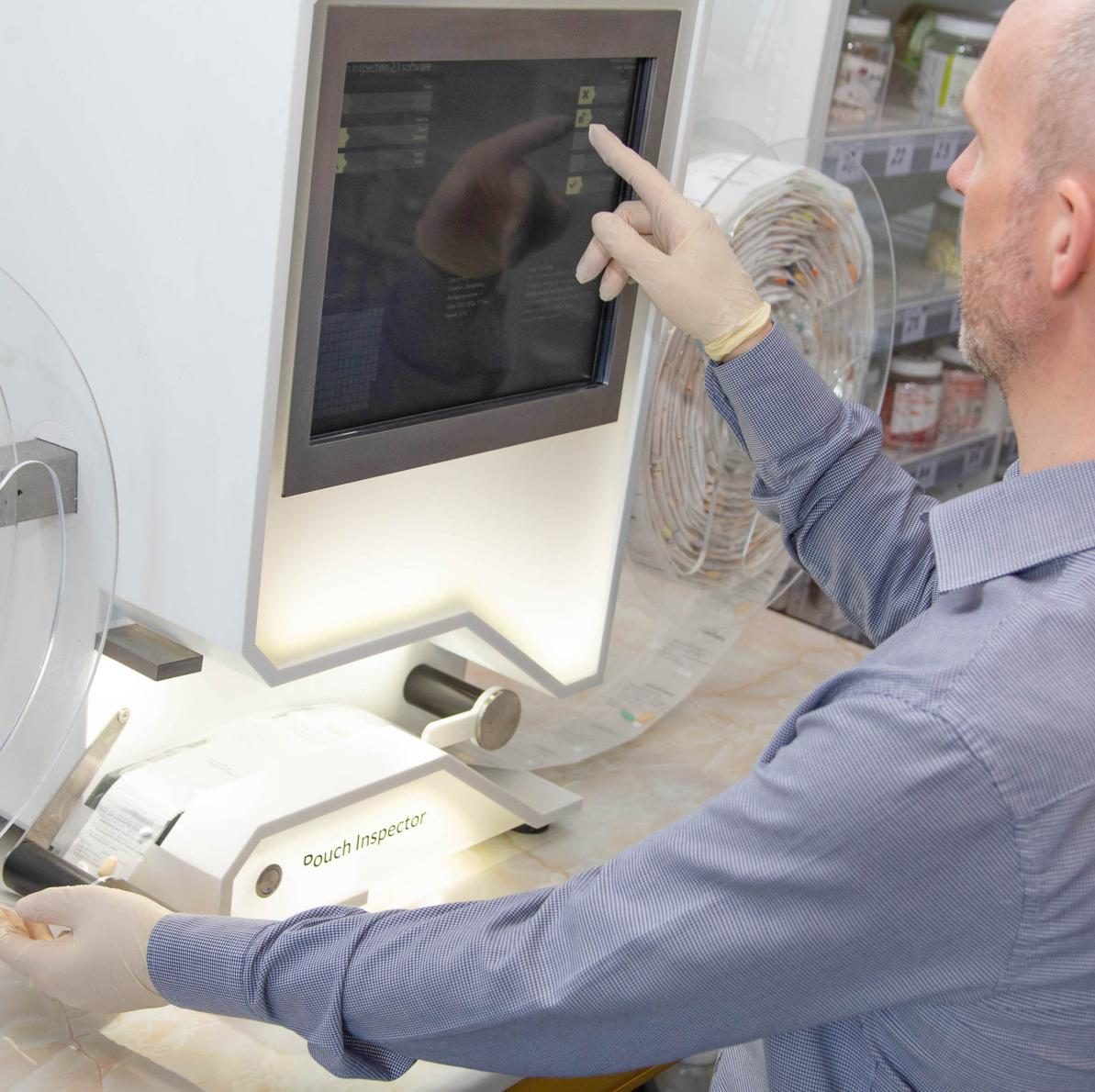A Chemco pharmacist checking a Tosho roll on the pouch inspector